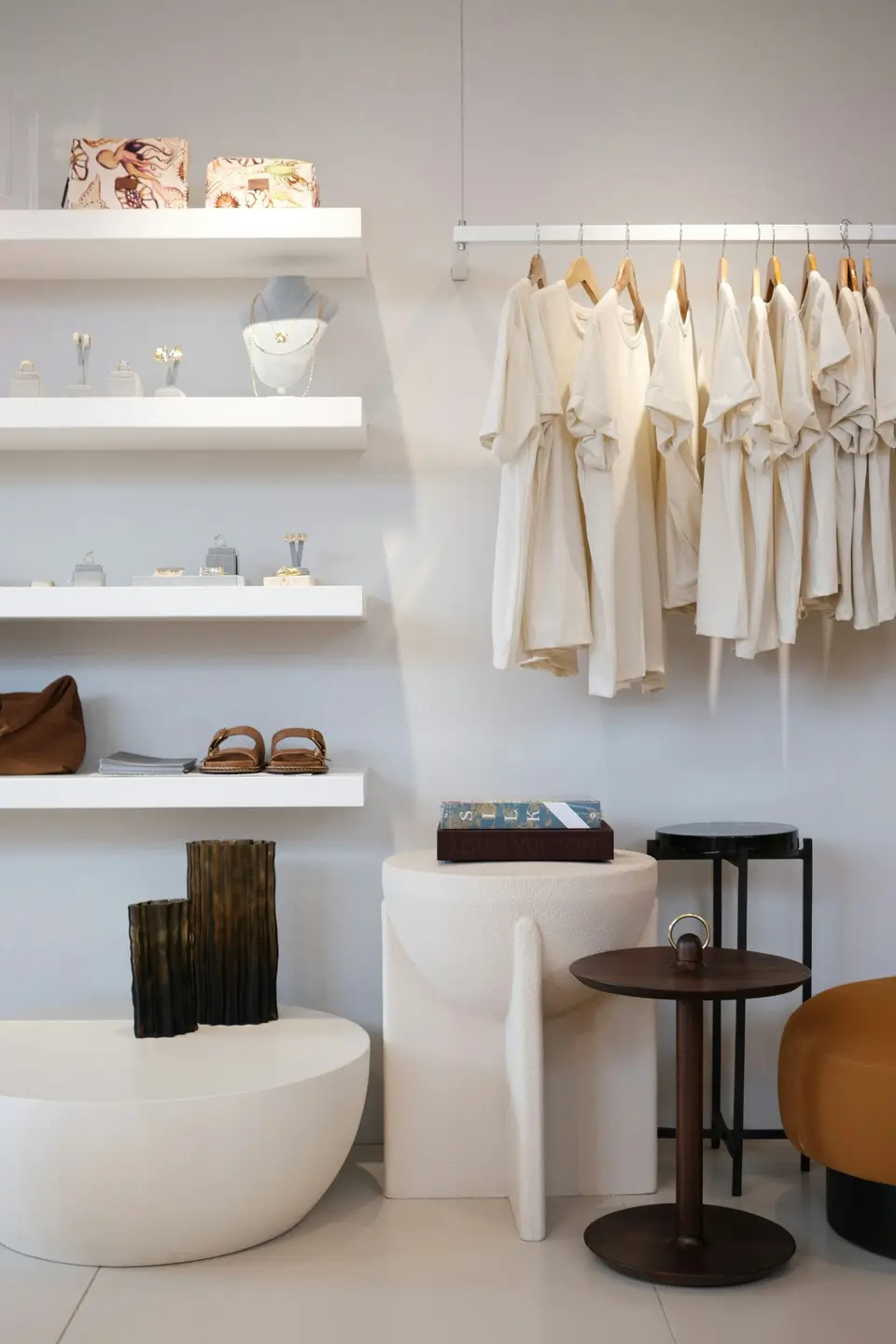 Hyllor och klädstång med ljusa plagg i en butik